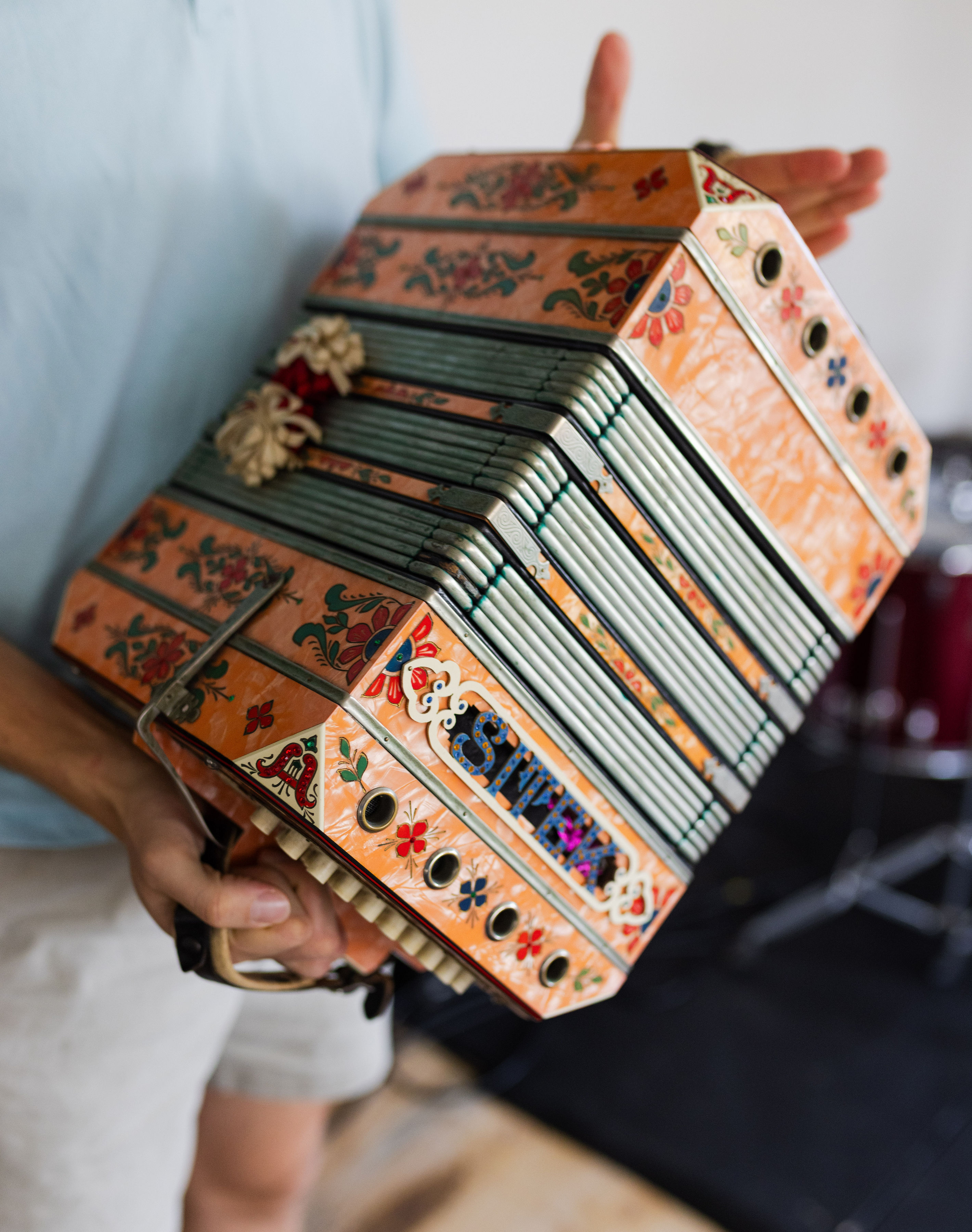 A young man holding a square orange instrument